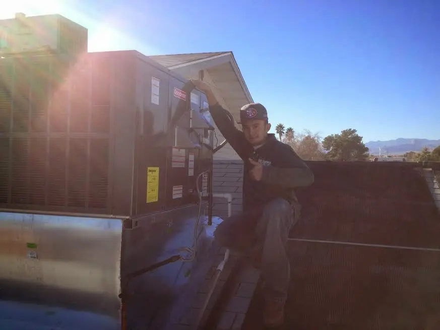 HVAC technician performing Air Duct Cleaning on a rooftop unit in Marlborough