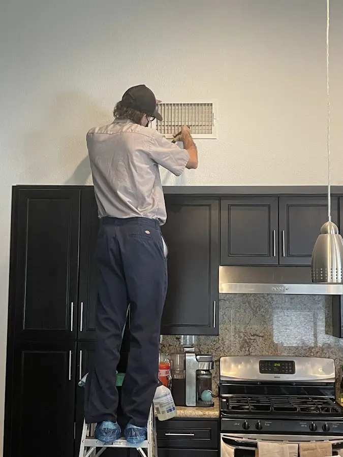 Technician inspecting an air vent during HVAC service in Marlborough